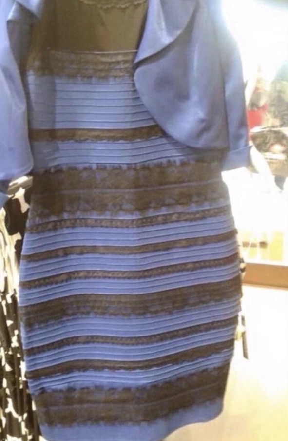 Image of a striped dress with a small bolero jacket attached. The dress is bodycon with horizontal stripes alternating between the dress fabric and a darker lace stripe. The background is out of focus but quite bright and overexposed. To some people, the dress appears to be a fairly dark blue and the lace stripes appear black. To others, the dress appears a slightly off-white colour and the lace appears a yellowy gold colour.